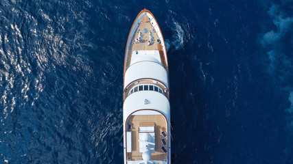 Aerial drone photo of luxury yacht with wooden deck in deep blue sea of iconic island of Mykonos...