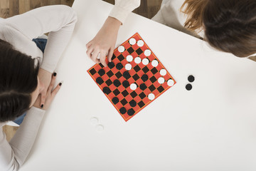 Top view women playing checkers