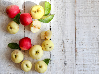Green and red organic apples on a white wooden table