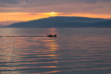 silhouetted boat on the calm waters of Lake Iznik at sunset