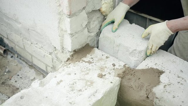 men's hands put cement mortar on the silicate blocks