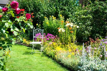 Beautiful garden with chair - obrazy, fototapety, plakaty