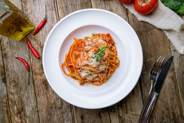 Pasta spaghetti Bolognese on white plate on wooden table