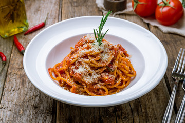 Pasta spaghetti Bolognese on white plate on wooden table