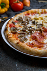 Pizza four seasons on dark concrete background