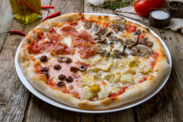 Pizza four seasons on wooden table