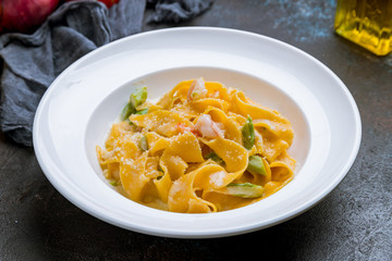 Pasta fettuccine with shrimps on dark concrete background