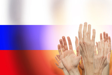 People raising hands and flag Russia on background. Patriotic co
