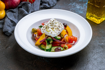 Greek salad with feta on dark concrete background