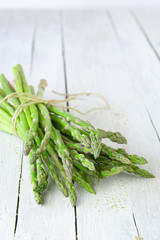 bunch of asparagus on white wooden table