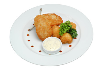 Nuggets on a plate with sauce and parsley, on a white isolated background