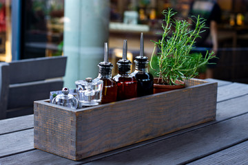 Olive oil, soy sauce , sesame oil standig in a glass bottle in a wooden box with greens