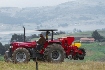 Red tractor working on field