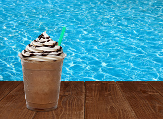 Frappuccino or iced coffee with whipped cream and chocolate syrup in disposable or plastic to go...