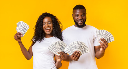 Happy african-american man and woman holding dollars