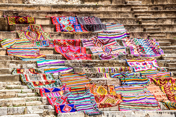 Many colored carpets laid out on the steps of the amphitheater. Carthage. Tunisia.