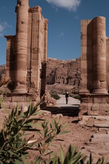 a person walking through ruins of ancient temple in Petra Jordan