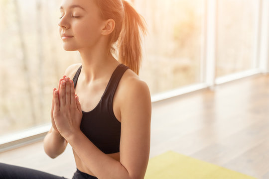 Woman meditating with closed eyes in bright light
