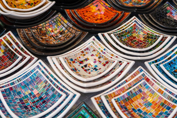Colorful mosaic decorative plates on the market for sale on local street market in Ubud, island Bali, Indonesia . Souvenirs for tourist