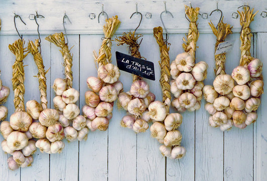 strings of garlic on old wooden background