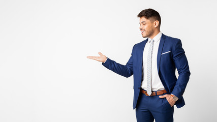 Smiling Businessman Presenting Something On Empty Palm Over White Background