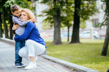 Lovely mother hug and carry her son. Preparing to send her children back to school in morning....