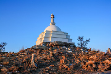 Buddhist stupa in the rays of the setting sun on the island of Ogoy on Baikal
