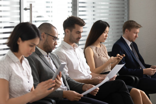 Business people applicants prepare for job interview sit in row
