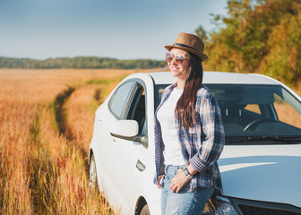 Beautiful woman with white car in the field