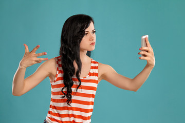 Studio photo of a gorgeous girl teenager posing over a blue background.