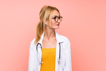 Young blonde doctor woman looking side