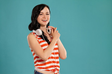 Studio photo of a gorgeous girl teenager posing over a blue background.