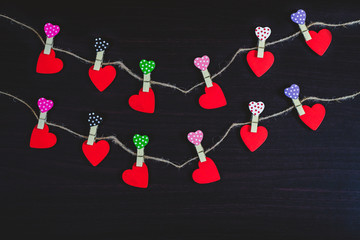 Red hearts hanging on rope on wood background