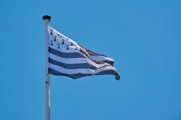 waving flag of Brittany against blue sky