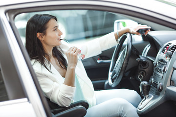 Young attractive lady in the car. Business woman in the automobile. Female driving auto.