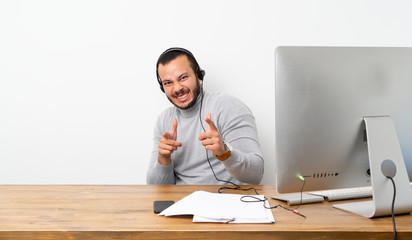 Telemarketer Colombian man pointing to the front and smiling