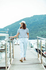 woman in white fashion luxury view walking by dock boats on background