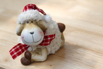 The smile teddy sheep on the wooden table.