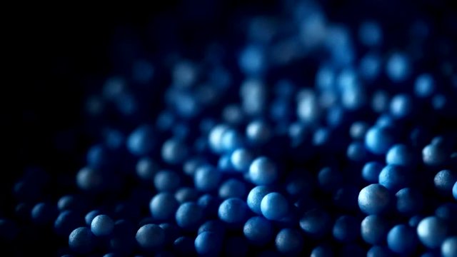Blue polystyrene foam balls moves along the surface of the water.
