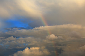 Naklejka na ściany i meble Beautiful heavenly landscape. Rainbow in the sky among the clouds