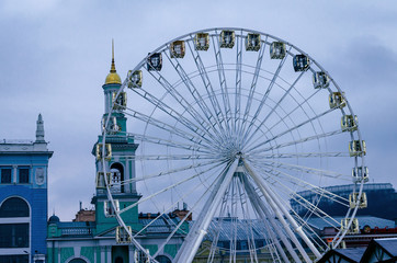 Ferris wheel on the background of the city and the cloudy sky