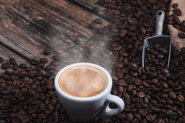 cup of espresso coffee and beans on wooden table