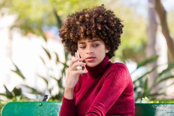 Outdoor portrait of a Young black African American young woman speaking on mobile phone