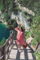 woman walking by hiking trail around braies lake in italy dolomites mountains. activity leisure lifestyle