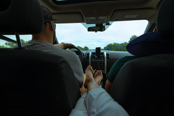 woman sitting at backseats of car put legs on armrest sunroof