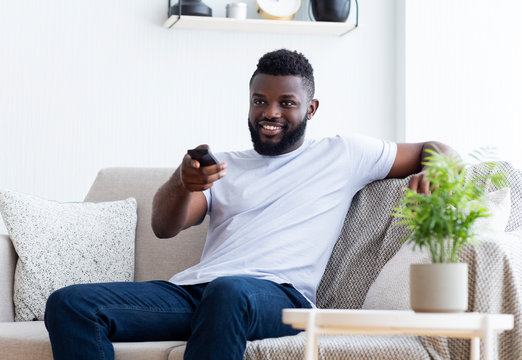 Young African American Man Watching TV At Home