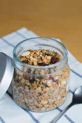 granola with peanuts, hazelnuts, oat and wheat flakes in glass bowl