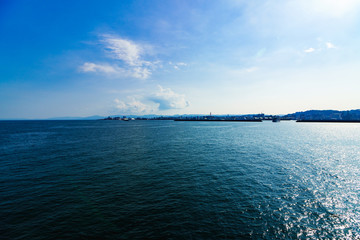[鹿児島市の交通イメージ] 初夏の快晴の鹿児島港を背景に，桜島に向かう桜島フェリー
