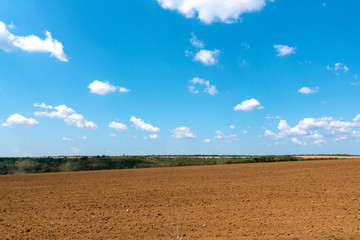 Landscape. Plowed field on the background of a beautiful summer sky