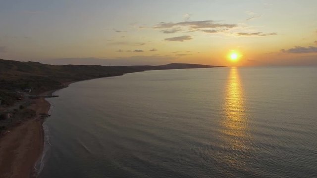 Sunset on beach.  AERIAL: Landscape of sea coast at sunset. Sea ​​bay near island at sunset, aerial video